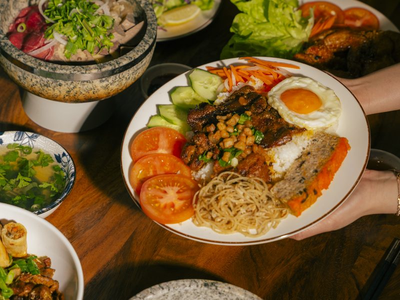 Cơm Sườn Bì Chả — broken rice with grilled pork, fried egg and egg meatloaf, served to the table